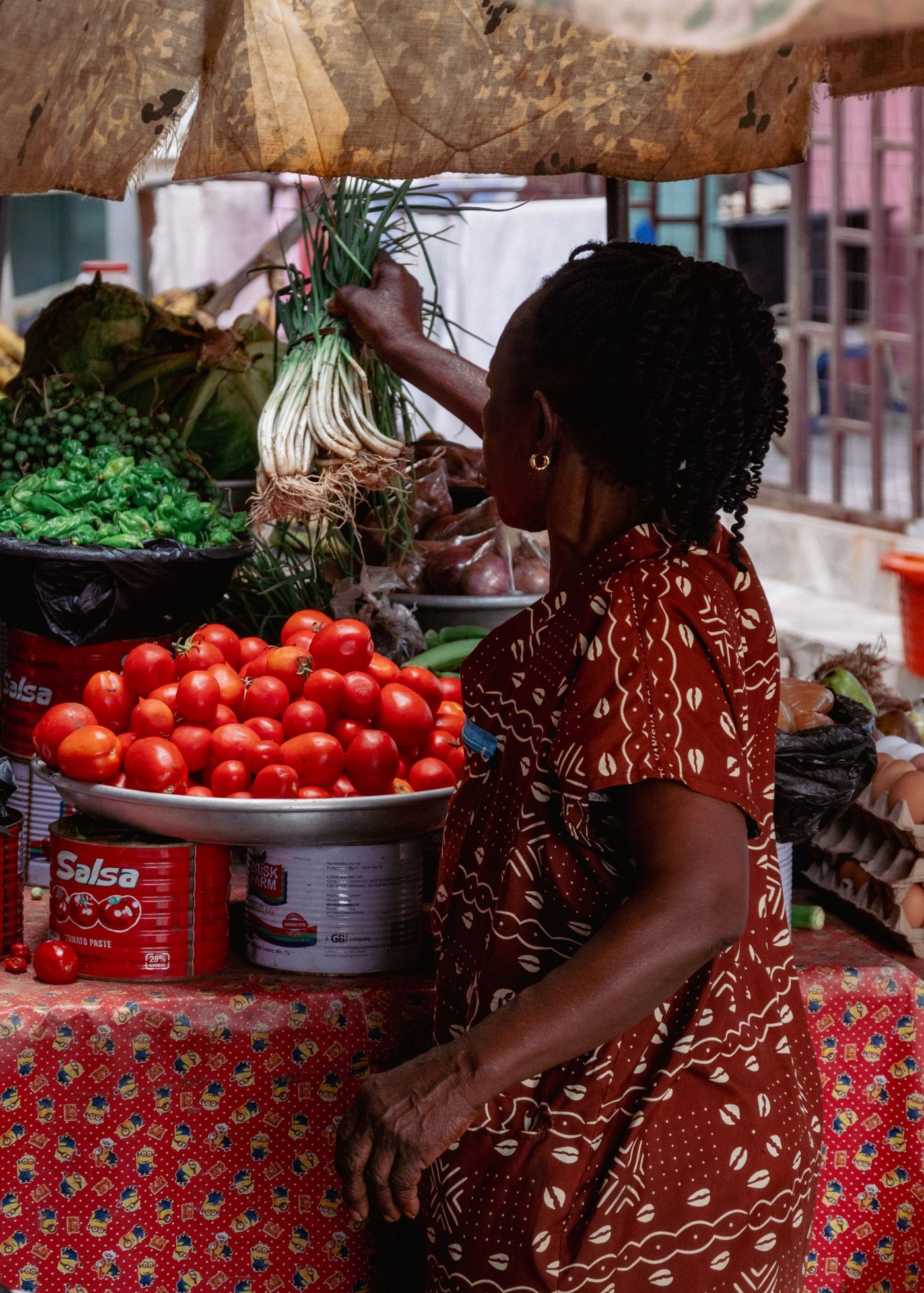 A woman choosing fresh produce at a market in Ghana